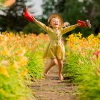 Little-girl-red-rubber-boots-straw-hat-watering-red-watering-flowers-garden (1)